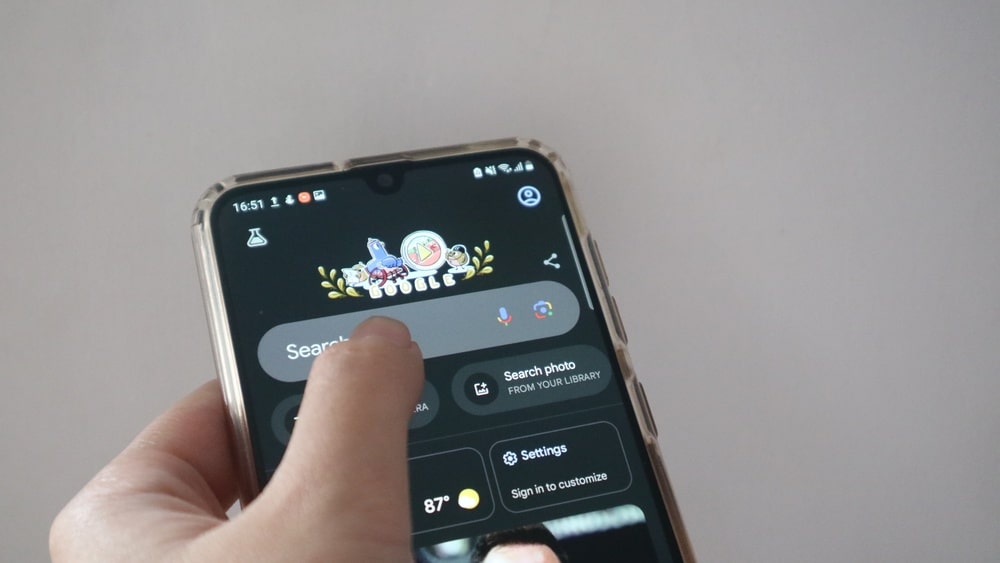 person on phone tapping google search bar