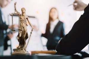 Lady Justice statue symbolizing legal integrity with attorneys working behind, representing law firm SEO strategy