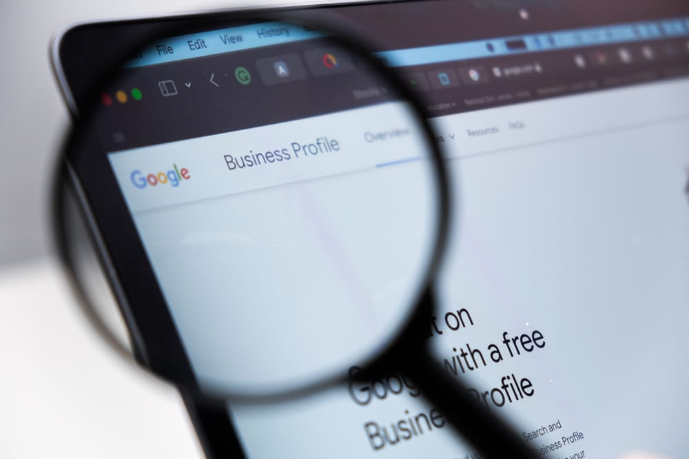 Google Business Profile logo on the screen of laptop through magnifying glass