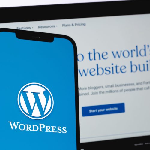 phone in front of laptop with wordpress logo